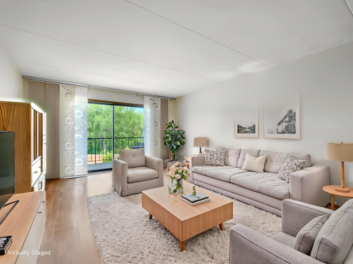 The unit has laminate flooring with a rich wood look throughout. Virtually staged photo.