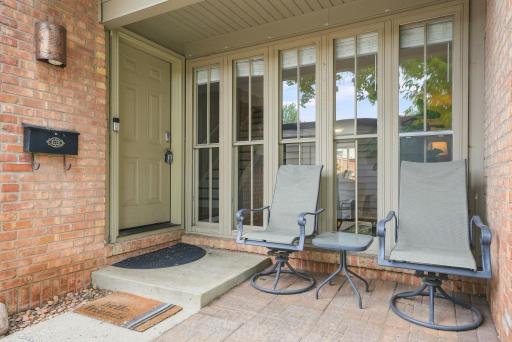 Charming front patio seating adds an inviting spot to enjoy your morning coffee.