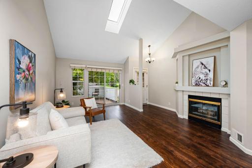 Soaring vaulted ceilings and a skylight fill the living room with natural light, creating a bright and inviting space to relax and gather.
