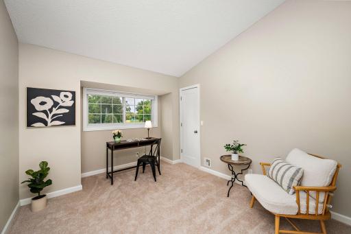 Comfortable second bedroom with vaulted ceiling and walk-in closet offers flexibility for guests or a home office.