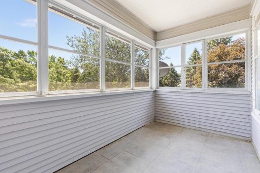 Off the upper level sunroom, there is a charming screened porch