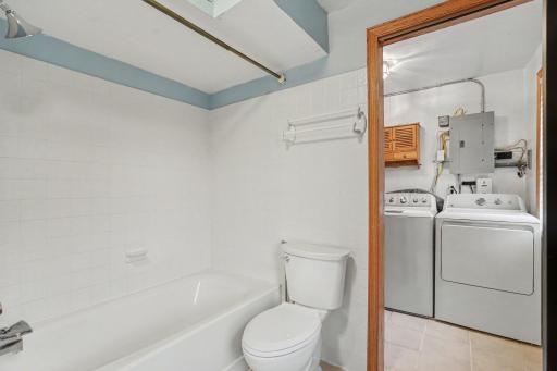 Walk through to a full laundry room / mechanical area.