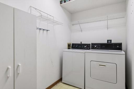 Convenient main-level laundry room with built-in shelving and additional storage space.