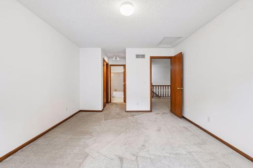 Upper-level bedroom features direct access to a full bath and closet, creating a second suite-like setup.