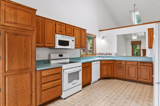 Plenty of cabinetry and workspace in the kitchen, with natural light from the vaulted ceiling and skylights.