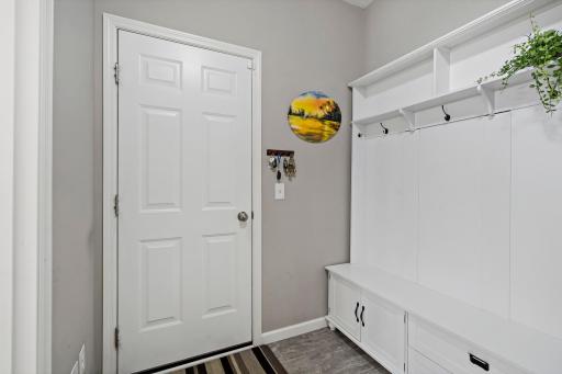 Entrance from the garage is well planned with coat closet, coat hooks, and storage bench.