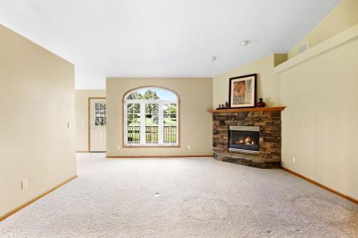 This living room is so welcoming with the stone fireplace, large windows and high ceilings