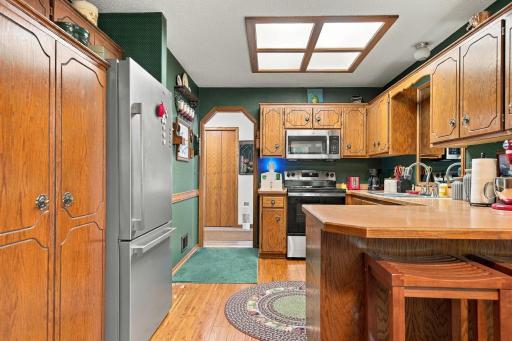The kitchen offers hardwood floor and wood cabinets