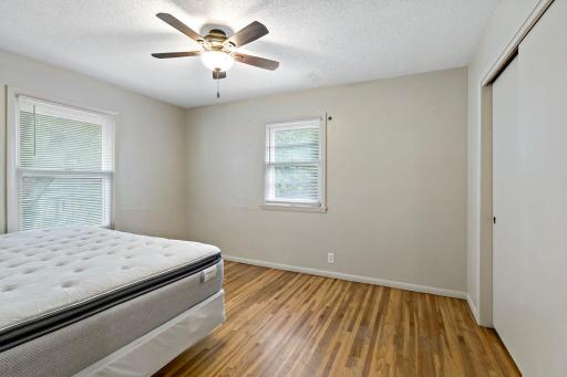 Second bedroom with hardwood flooring and ceiling fan.
