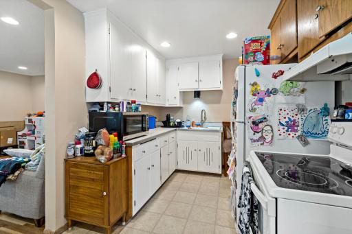 Kitchen with electric range and refrigerator. Microwave is owned by the tenant.