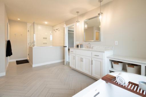 You will feel like you're at a spa in the primary bathroom that has a 35 square foot shower with two shower heads, double sinks, and a tub with views of the lake.