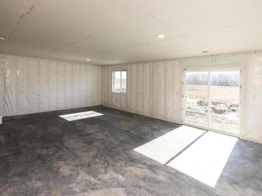 Unfinished Lower Level. Photo taken of another home with similar plan and finishes. Photos and renderings may not depict actual plan, materials, & finishes may vary. All measurements are approximate.