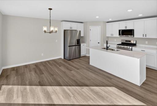 Dining Room & Kitchen. Photo taken of another home with similar plan and finishes.