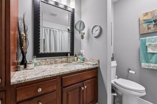 Custom cherry cabinets and granite counters in the main level full bath. There is a cast iron tub and tile shower surround in this bath.