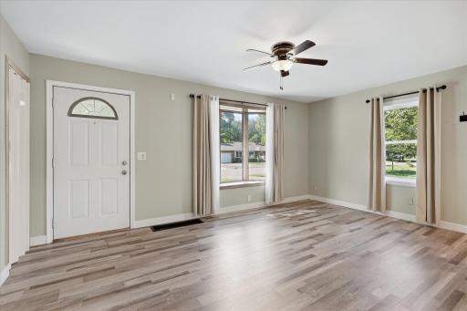 Natural light pours into the living room through multiple windows overlooking the front yard.