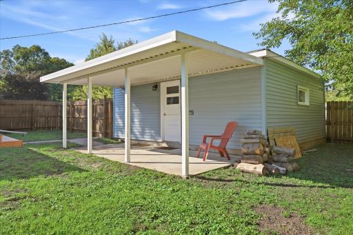 A covered patio alongside the garage offers a shaded spot for outdoor dining, grilling, entertaining, or simply relaxing outside.