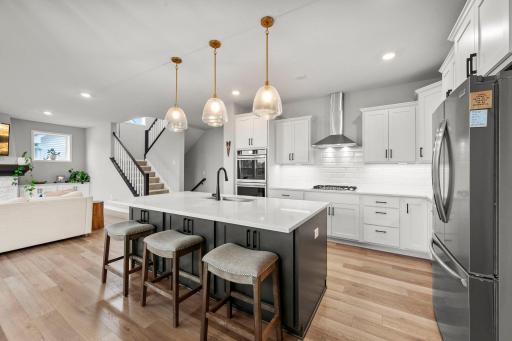 Large center island with seating, storage, and outlets.