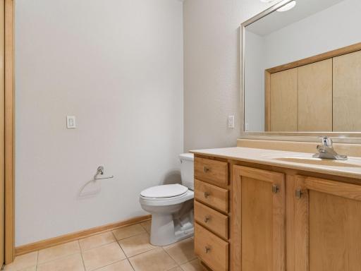 Convenient second bathroom with attractive wood cabinetry.