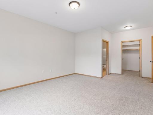 Spacious walk-in closet with built-in shelving and hanging space.