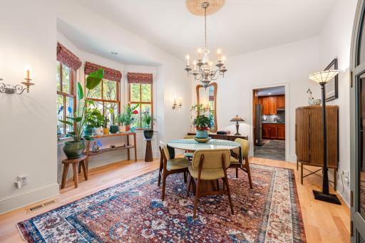 The formal dining room impresses with its large window, elegant chandelier, fresh paint, and custom remote-controlled window coverings,