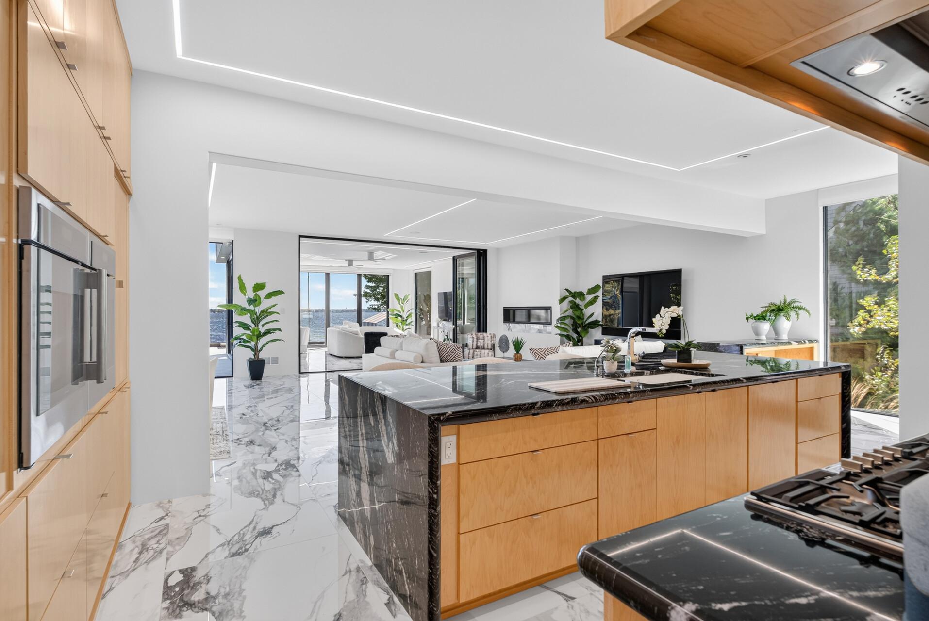 At the center, a dramatic 12-ft island with waterfall countertops enhances the sleek design.