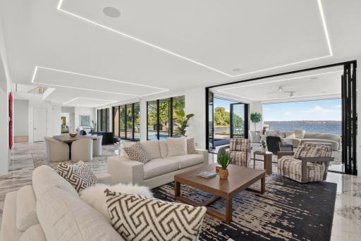 Floor-to-ceiling windows span the entire south side of the home, filling the interiors with natural light and uninterrupted lake views.