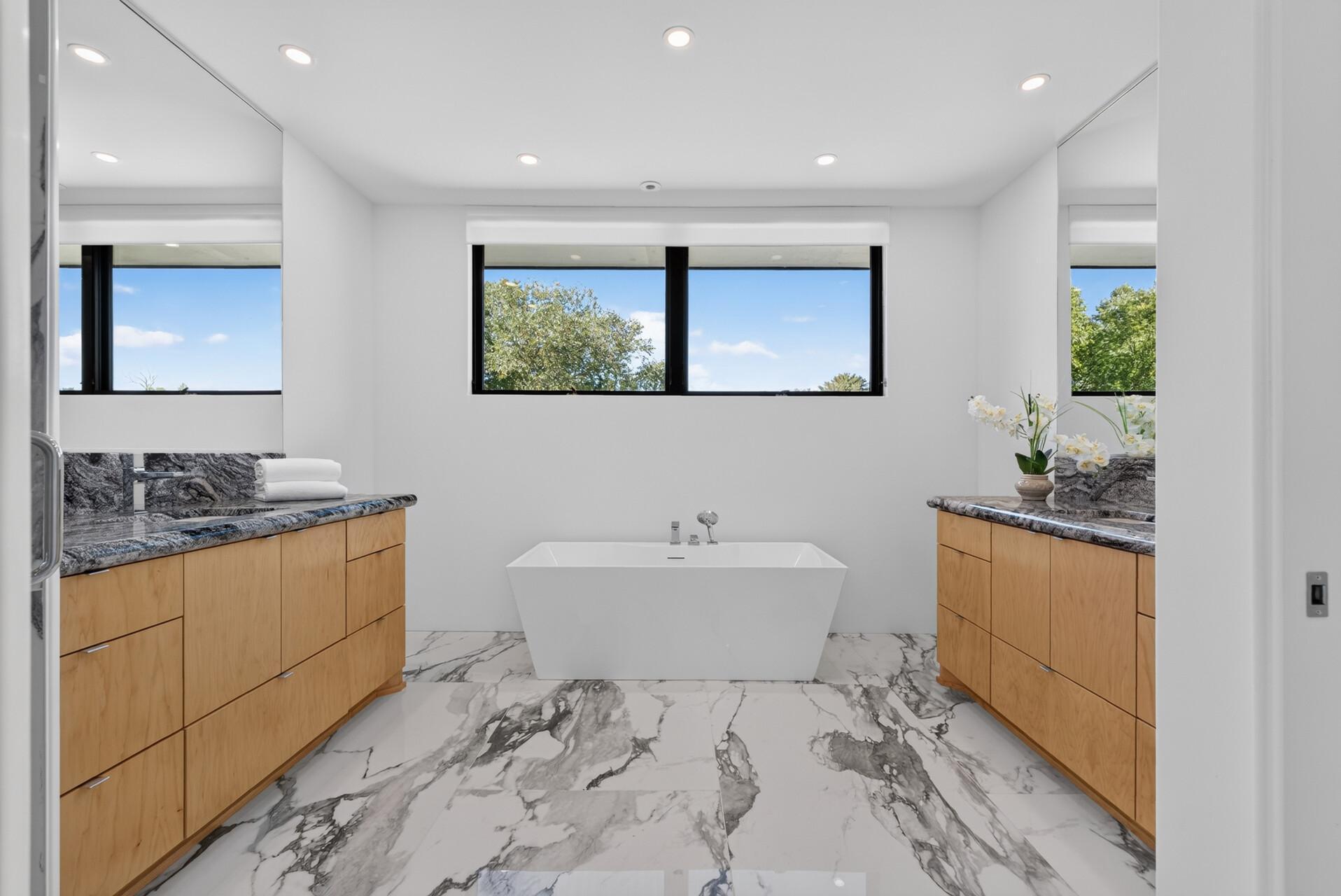 Beautiful ensuite with two separate vanities and a freestanding tub.