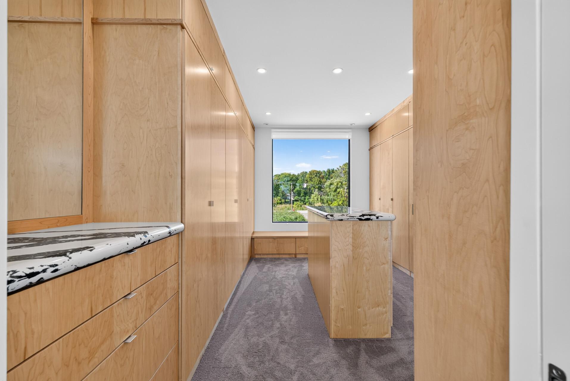 Walk-in closet with custom built-ins and center island.