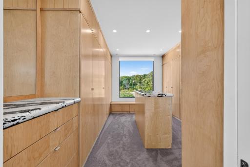 Walk-in closet with custom built-ins and center island.