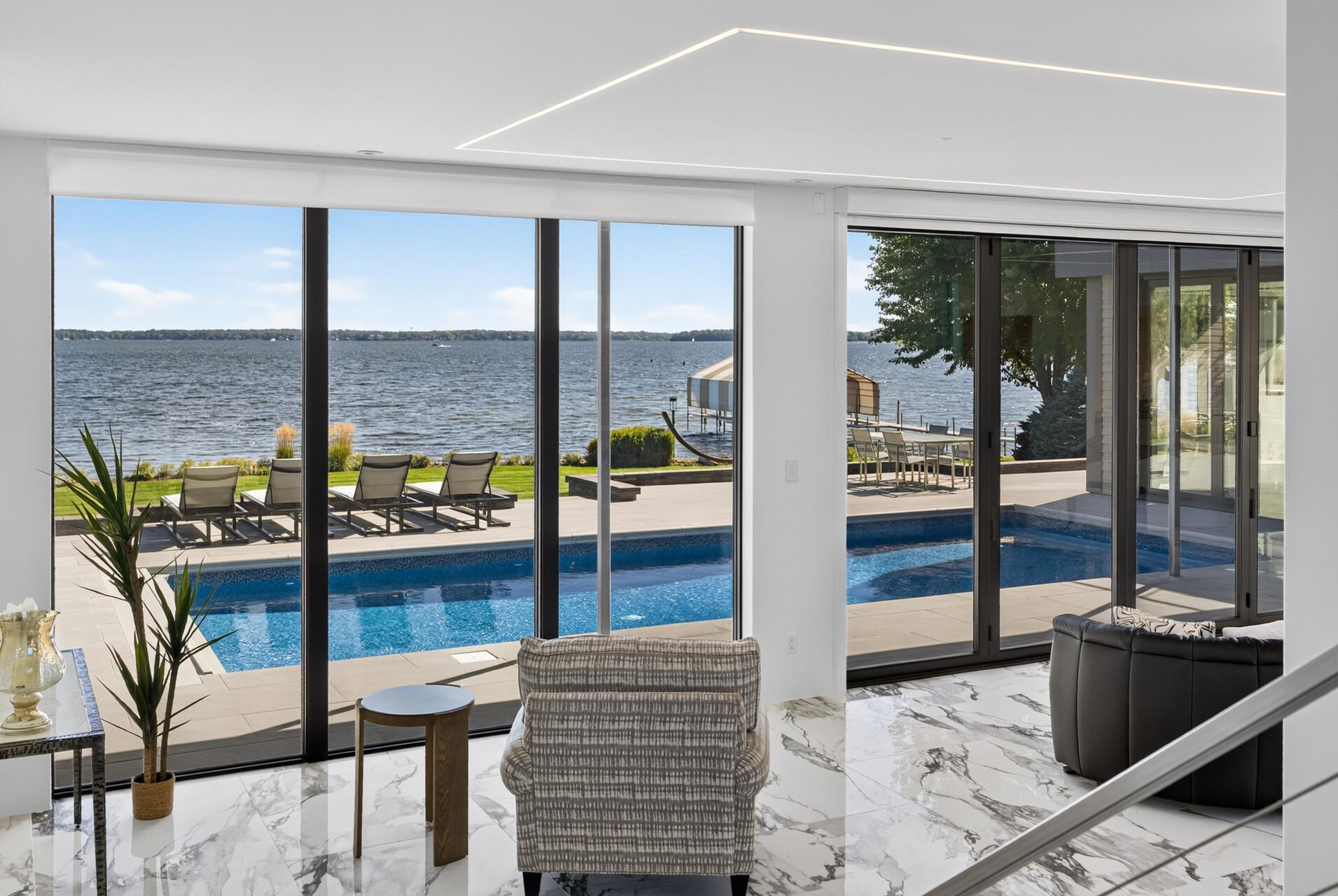 Expansive accordion doors open fully from the living room, creating a seamless connection between the interior and exterior and allowing the two spaces to come together as one for entertaining and enjoying the lakefront setting.