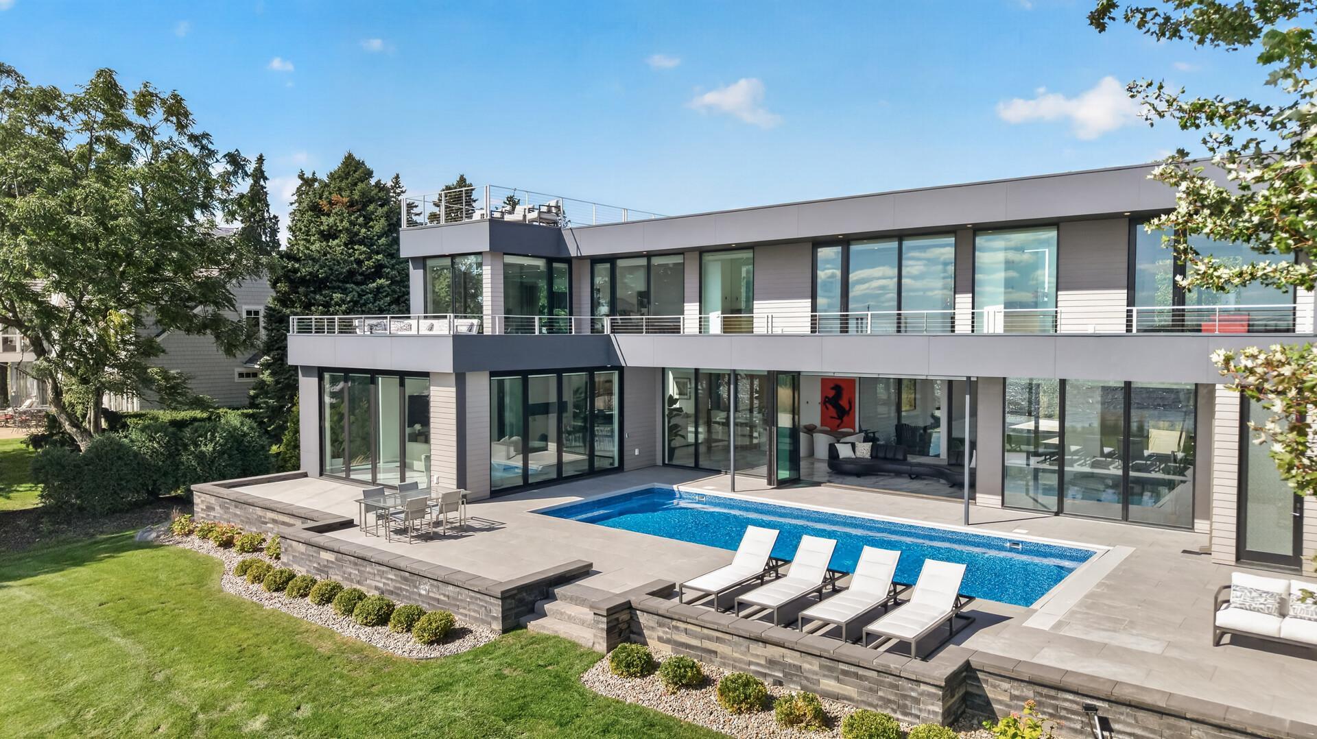 Outside, the lakefront lifestyle continues with an expansive pool deck surrounding the heated inground pool and private hottub.