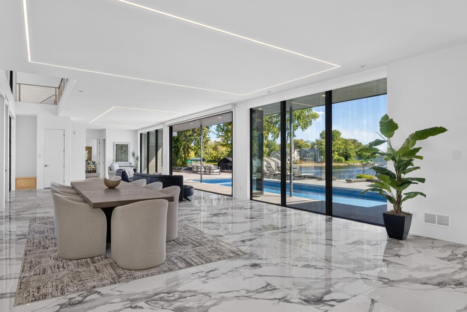 The open-concept, modern floorplan is defined by sleek, continuous finishes and expansive tilework throughout.