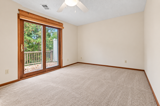 Primary Bedroom with walk out to lake facing deck. Virtually enhanced. Furniture and personal belongings removed.