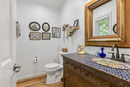 Vintage-inspired powder room with a unique vanity â full of character and charm.