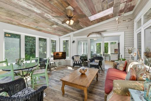 Bright, sprawling three season porch with a rustic wood-plank ceiling â a truly one-of-a-kind space to unwind.