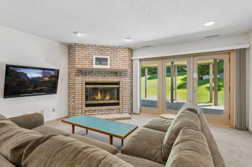 Gather around the classic brick fireplace in this warm, welcoming family room with walkout access to back patio.