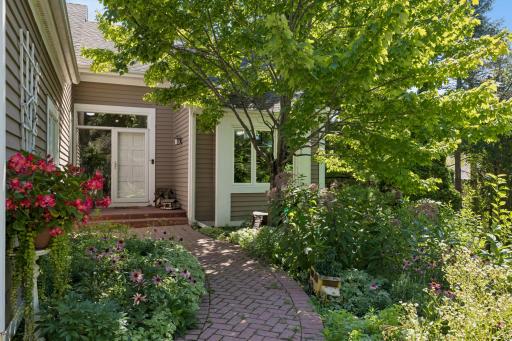 Charming front entry with garden beds bursting with color â the perfect first impression.