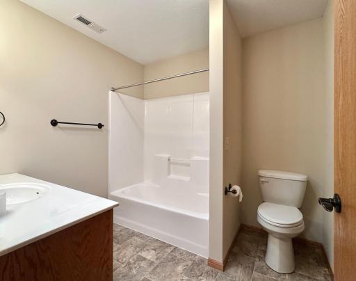 The hall bath shares space with the laundry area to the right.