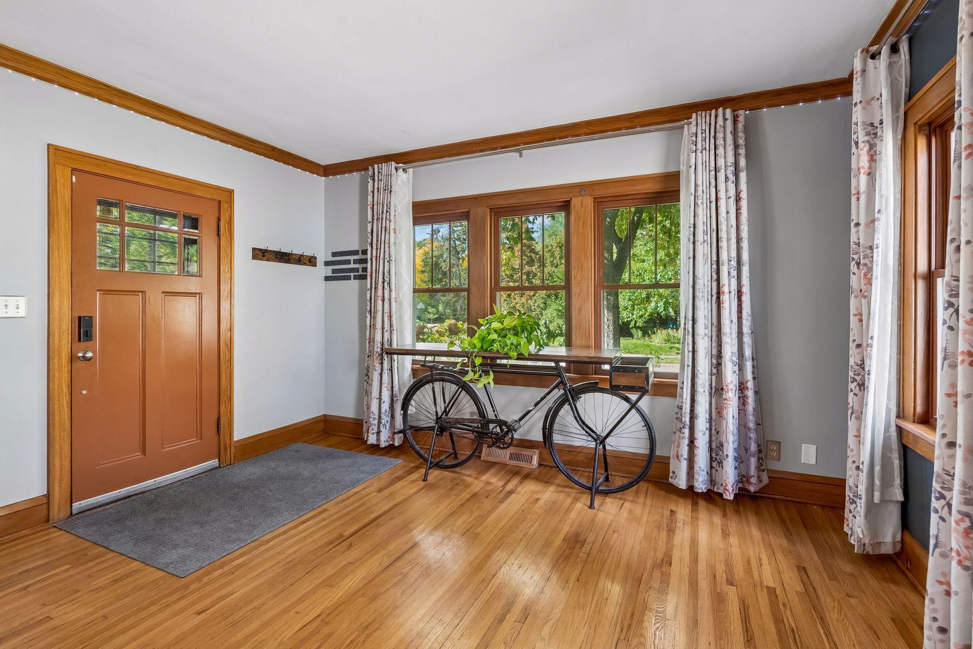 Step inside to gleaming hardwood floors, warm wood trim, and a wall of windows that fills the space with natural light. There's a handy spot by the door for coats and keys.