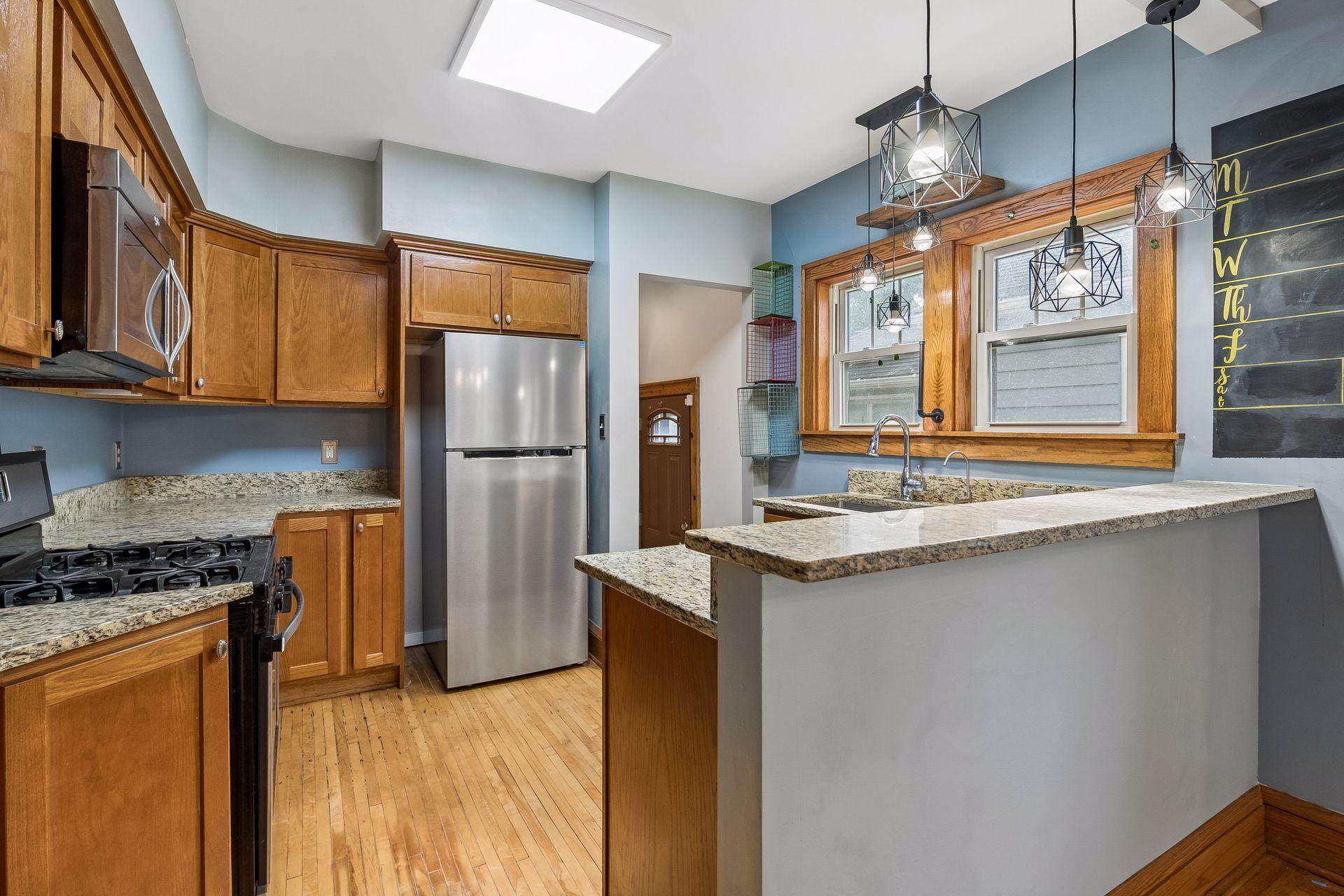 Stainless appliances, granite counters, and generous cabinet space fill this well-planned kitchen. A side door makes it easy to bring in groceries or head out to the yard.