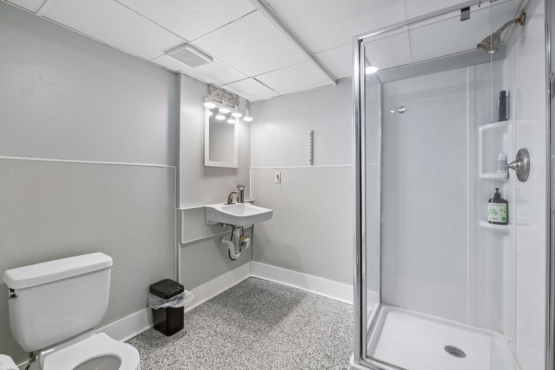 The lower level 3/4 bath has a glass-enclosed shower, a wall-mounted sink, and the same durable flooring as the family room. It's ideal for guests or the lower level bedroom.