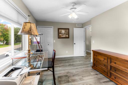 Bedroom #2 with walk-in closet, neutral colors, laminate flooring, natural light via oversize window.