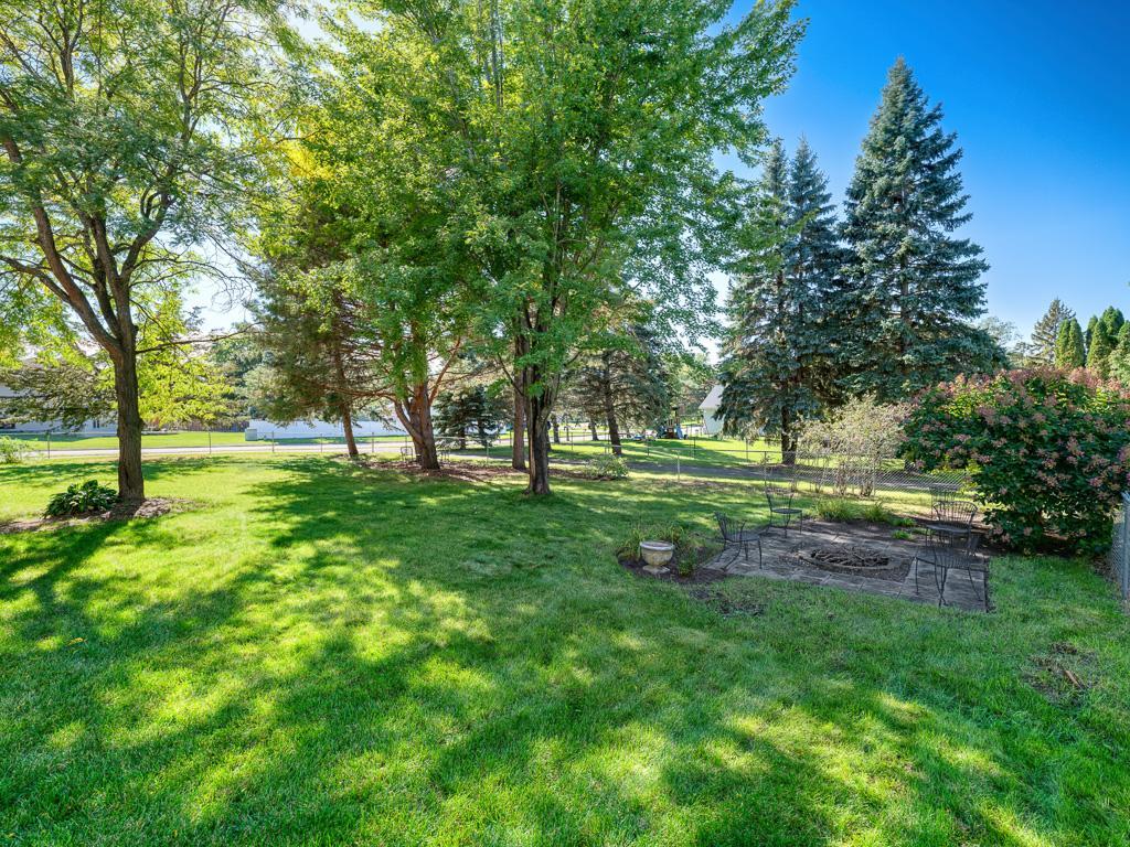 Fenced in backyard, firepit area, mature trees and lush grass (has a sprinkler sytem)