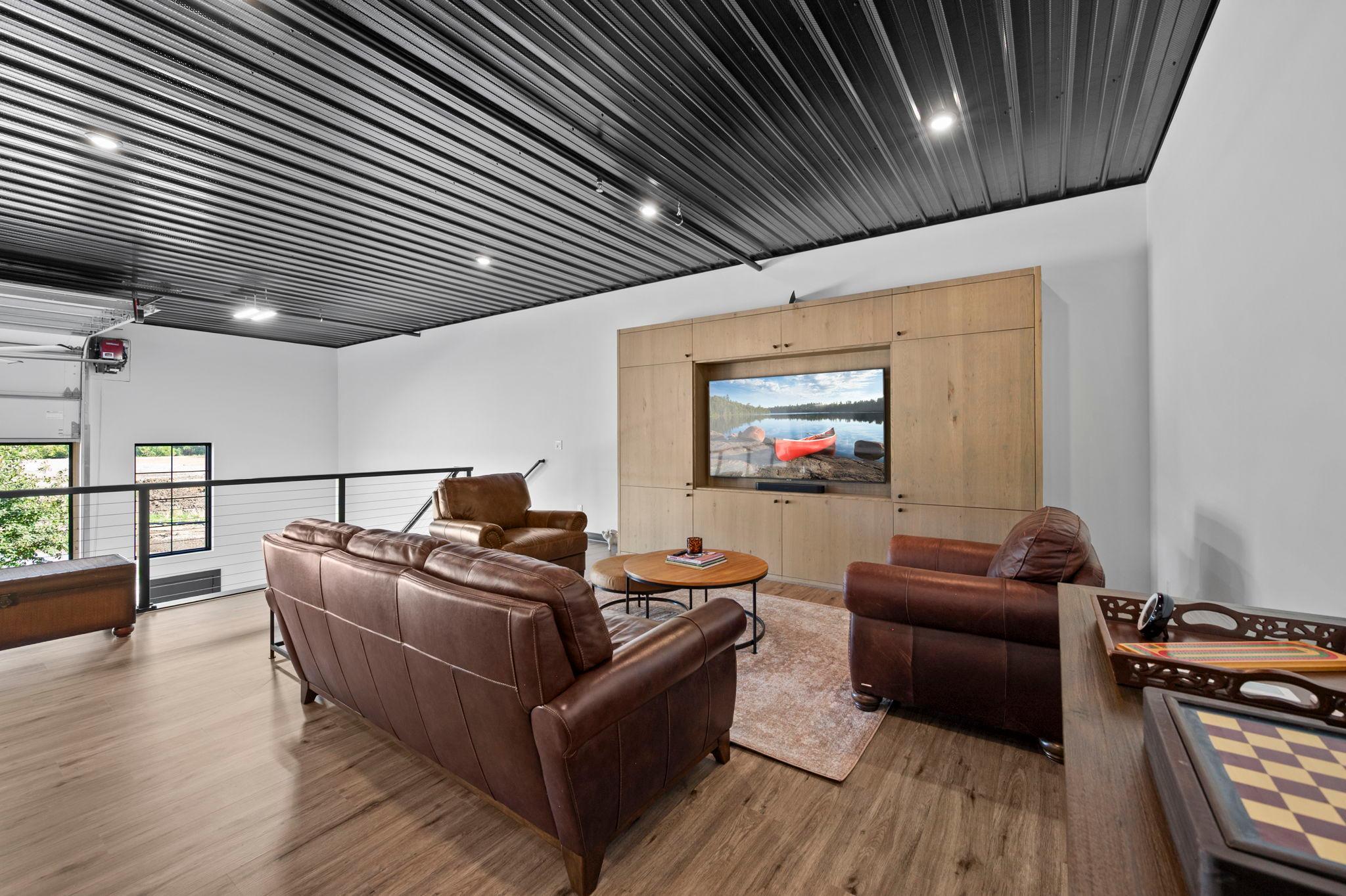 The 30’ wide by 20’ deep loft provides an impressive extension of the space with a comfortable living room or sitting area, custom cabinetry and entertainment center, and a 75” Samsung TV.
