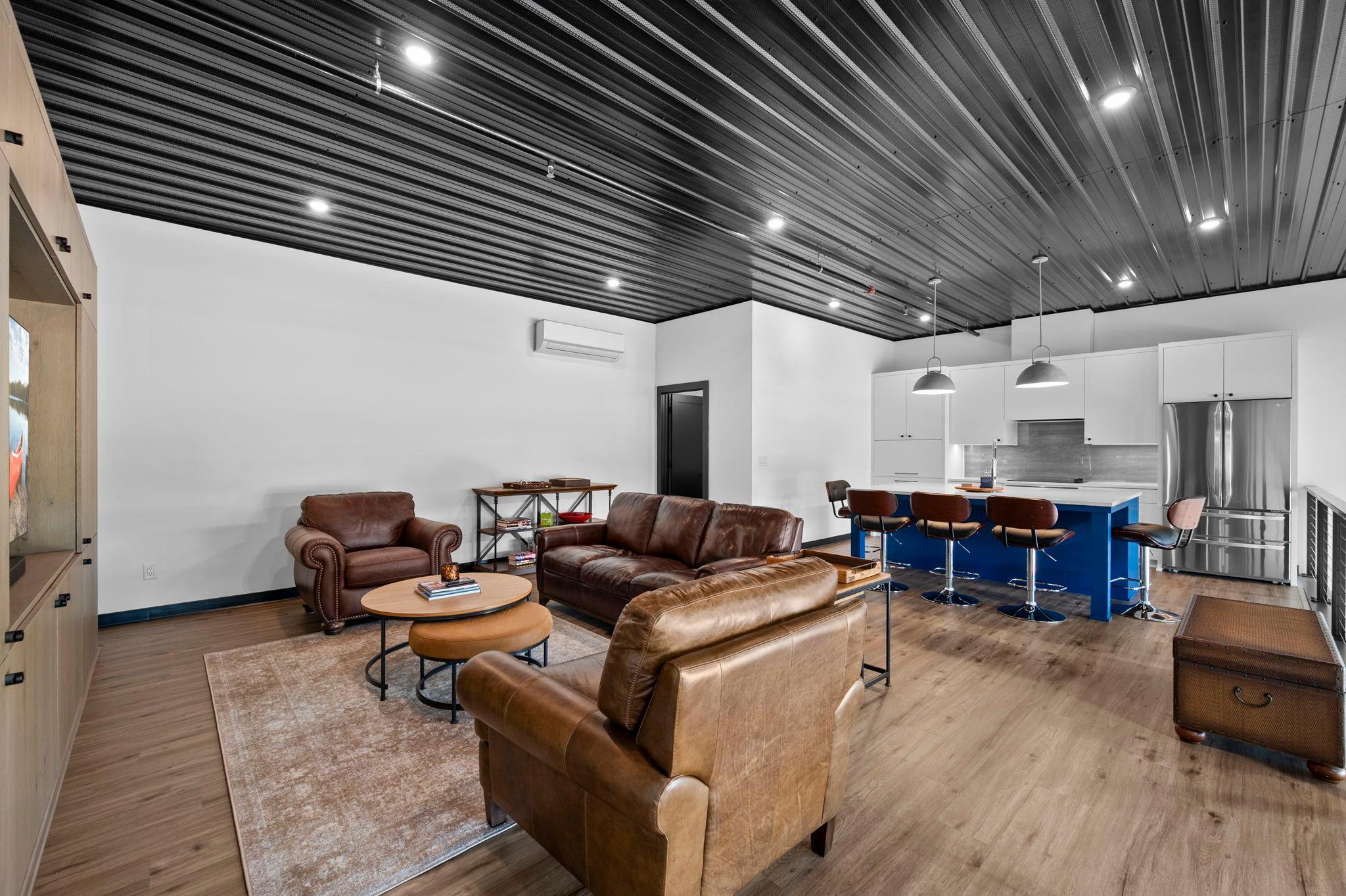 A different perspective of the living room showcases the nearby full kitchen.