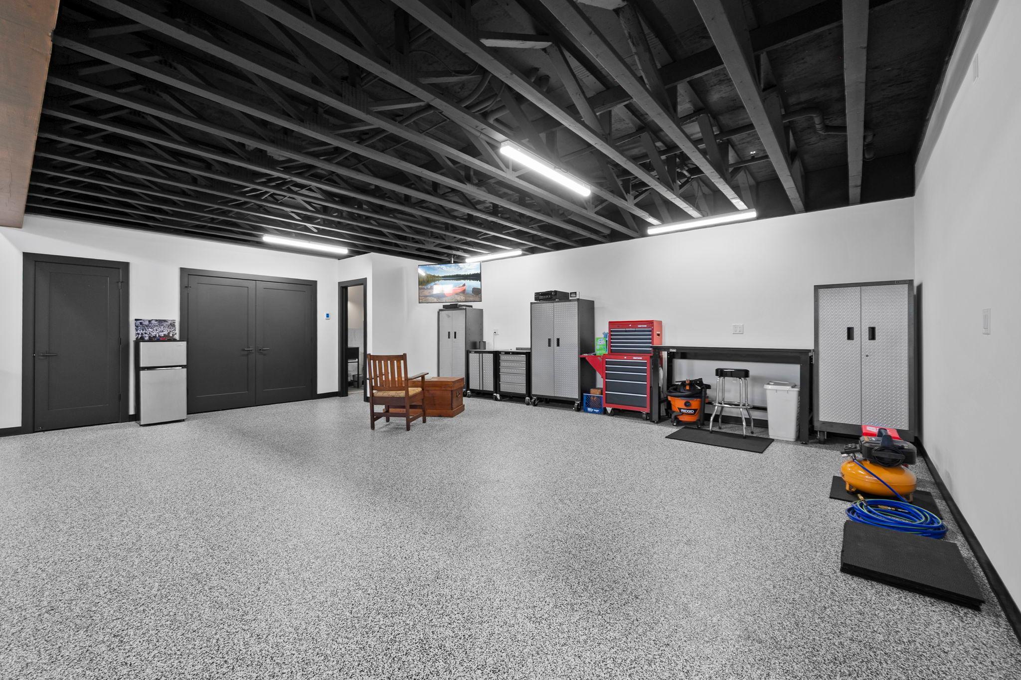 The lower level features epoxy floor coating, a 55” Samsung TV, ½ bath with a large utility sink, 40-gallon electric water heater, and water softener providing soft water throughout.