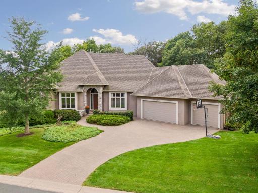 Custom Eden Prairie home featuring architectural details throughout, gourmet kitchen, main-level primary suite, finished walkout lower level and private backyard with infinity-edge pool.