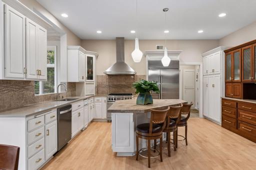 Spacious gourmet kitchen with large center island, abundant cabinetry, stainless steel appliances and professional-style range.