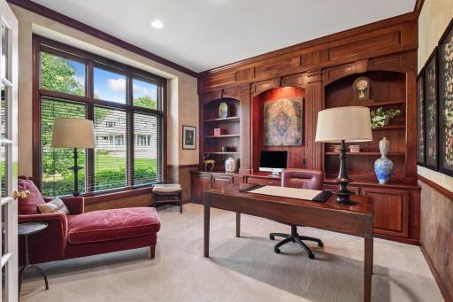 Richly finished main-level home office with extensive custom wood built-ins, cabinetry and workspace.