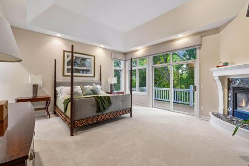 Spacious primary suite with fireplace, sitting area, large windows and private deck access.